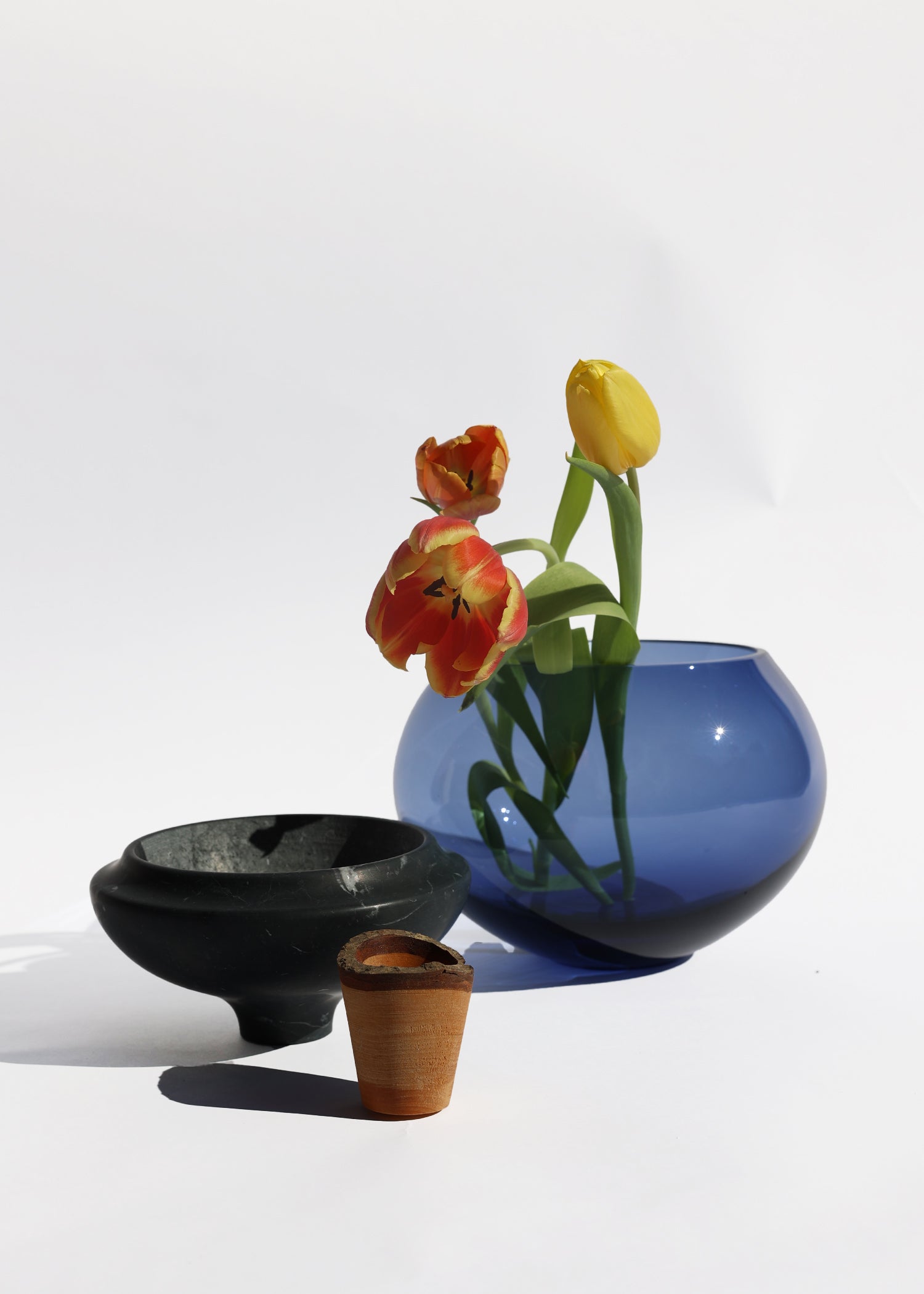  Istanbul Stacking Vessel in blue and black marble unstacked with flowers, a bold blend of colors that highlight the unique marble textures.