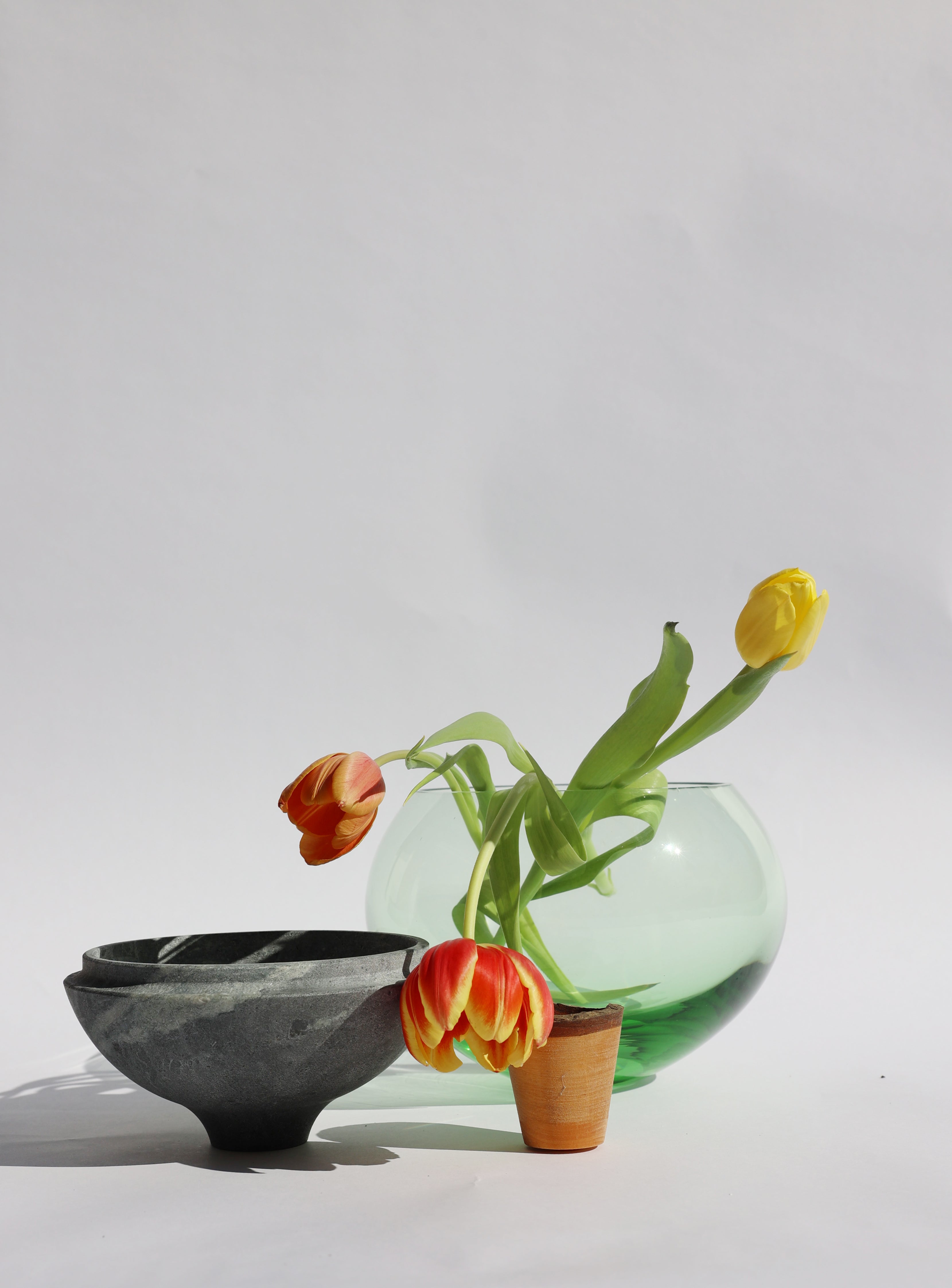 Istanbul Stacking Vessel in jade and soapstone unstacked with flowers, featuring a harmonious blend of green and neutral tones for a timeless look.