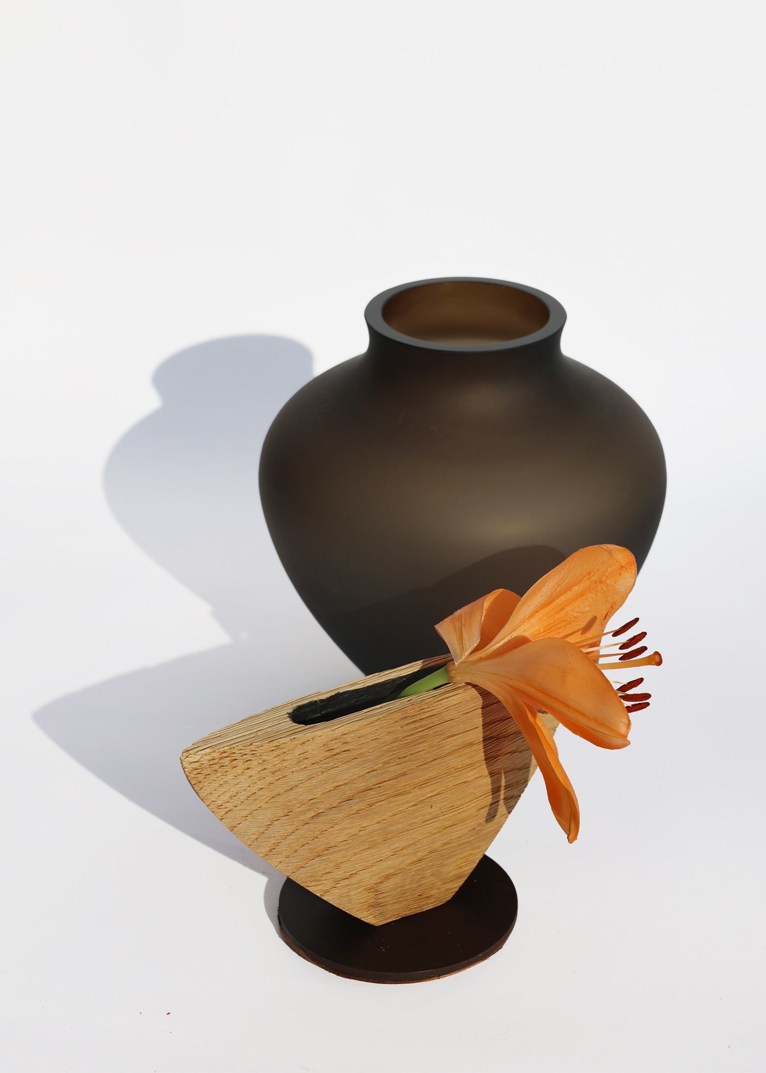 Ohana Stacking Vessel in Smoke Satin unstacked with lily, featuring a sophisticated blend of smooth textures and understated tones.