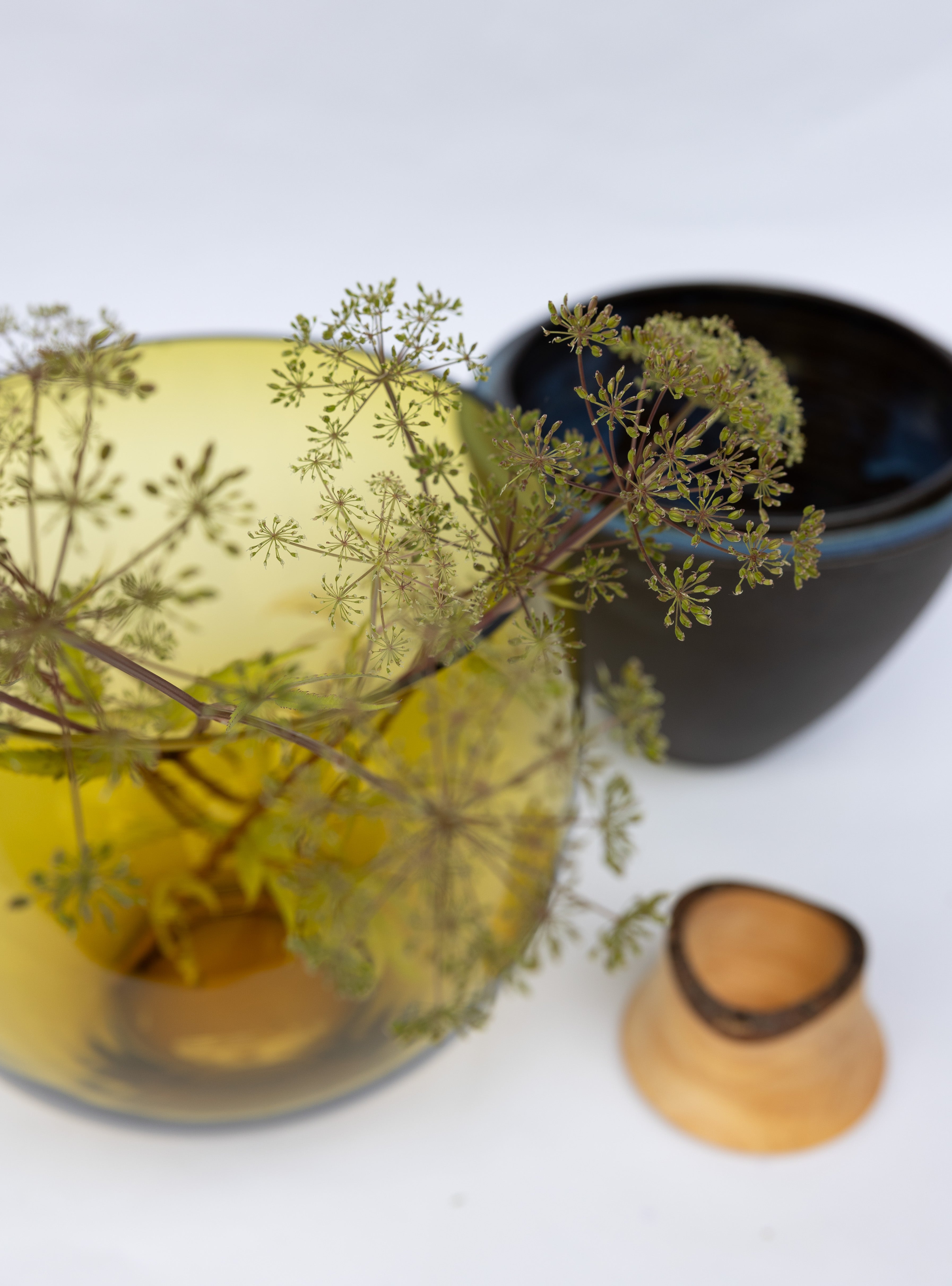 Transformed Stacking Vessel in Amber unstacked with flower, showcasing a warm-toned glass design with elegant stacked forms.