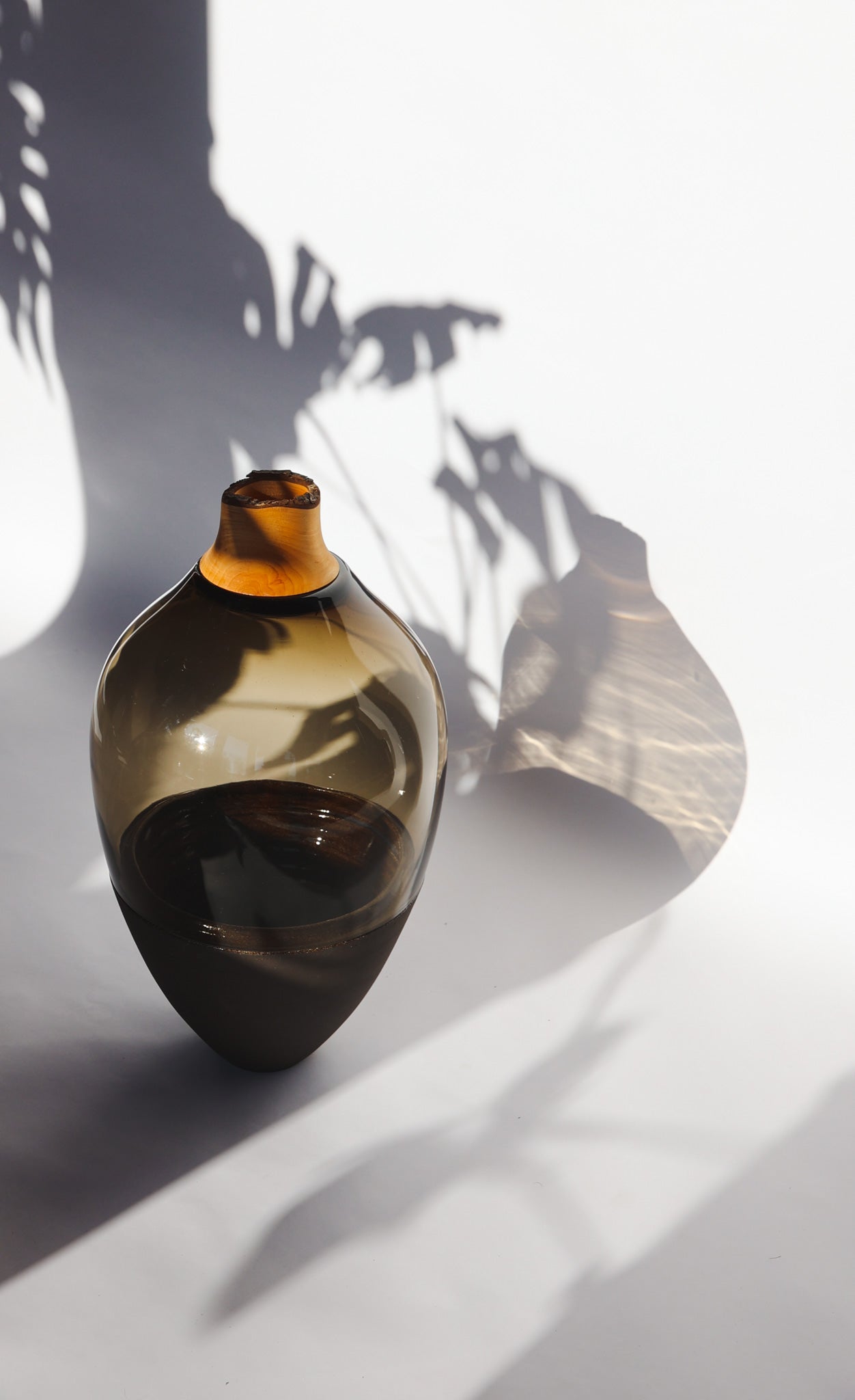 Transformed Stacking Vessel in Smoke, featuring a sleek, smoky glass composition with a sculptural stacked silhouette.